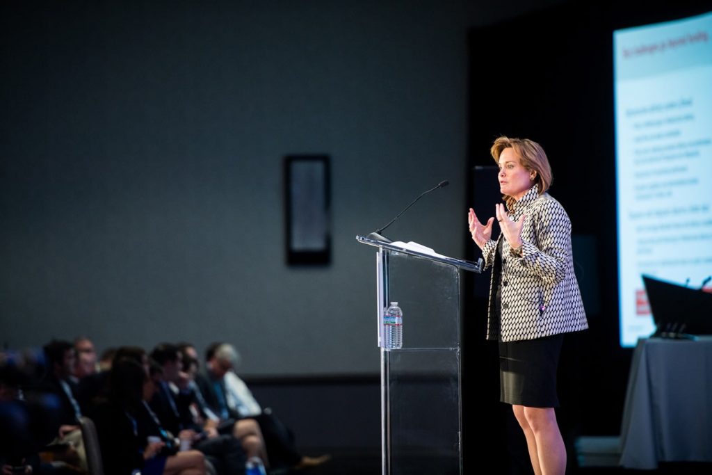 woman speaking behind lectern